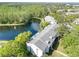 A scenic aerial view highlights the serene lakeside condo community, lush greenery, and a fountain at 1309 Pine Ridge E Cir # H3, Tarpon Springs, FL 34688