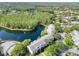 Lakeside condo buildings are surrounded by lush greenery in this scenic aerial view at 1309 Pine Ridge E Cir # H3, Tarpon Springs, FL 34688