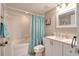 Bright bathroom with a shower-tub combo, modern vanity, and a stylish mirror at 1309 Pine Ridge E Cir # H3, Tarpon Springs, FL 34688