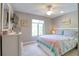 Cozy bedroom featuring a ceiling fan, large window, and a comfortable bed with pastel color quilt at 1309 Pine Ridge E Cir # H3, Tarpon Springs, FL 34688
