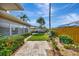 Landscaped backyard featuring a stone pathway and manicured lawn at 13850 Sunset Dr, Largo, FL 33774