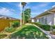 Backyard of home featuring manicured lawn, lush landscaping, and a wooden fence at 13850 Sunset Dr, Largo, FL 33774