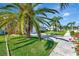 Charming single-story home with a well-manicured lawn, garage and bright pink front door at 13850 Sunset Dr, Largo, FL 33774