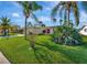 Lovely single-story home with a well-kept lawn and tropical landscaping including palm trees at 13850 Sunset Dr, Largo, FL 33774