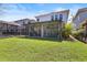 Backyard view of screened in patio and pool area with grassy lawn at 14241 Natures Reserve Dr, Lithia, FL 33547