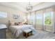 Cozy bedroom featuring a tray ceiling, ample natural light, and a decorative chandelier at 14241 Natures Reserve Dr, Lithia, FL 33547
