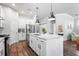 Modern kitchen features white cabinets, stainless steel appliances, and a large island with countertop seating at 14241 Natures Reserve Dr, Lithia, FL 33547