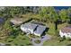 Aerial view of home with manicured lawn, mature trees, a screened pool, and playground at 16121 Carencia Ln, Odessa, FL 33556