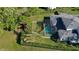 Home featuring a screened in pool, playground, and verdant landscaping at 16121 Carencia Ln, Odessa, FL 33556