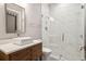 Elegant bathroom with glass shower, white marble tiling, and wood vanity with stone countertop at 16121 Carencia Ln, Odessa, FL 33556