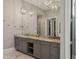 Bathroom featuring granite countertop vanity with dual sinks, large mirror, and modern lighting at 16121 Carencia Ln, Odessa, FL 33556