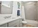Bathroom with gray tiled shower and tub, modern vanity, and a bright window at 16121 Carencia Ln, Odessa, FL 33556