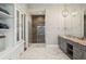 Bathroom with storage, granite counters, dual sinks, and glass shower with modern fixtures at 16121 Carencia Ln, Odessa, FL 33556