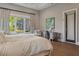 Sunlit bedroom showcasing hardwood floors, seating area, and desk near a window at 16121 Carencia Ln, Odessa, FL 33556