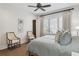 Bright bedroom with a large window, ceiling fan, wood floors, and decorative seating at 16121 Carencia Ln, Odessa, FL 33556