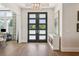 Elegant foyer featuring hardwood floors, a modern chandelier, and double doors with frosted glass at 16121 Carencia Ln, Odessa, FL 33556