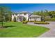 This house is set back on a sprawling green lawn with mature trees and a circular driveway at 16121 Carencia Ln, Odessa, FL 33556