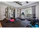Fully equipped home gym with a variety of machines, weights, and a large window for natural light at 16121 Carencia Ln, Odessa, FL 33556