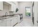 Functional laundry room featuring granite countertops, white cabinets, and modern washer and dryer at 16121 Carencia Ln, Odessa, FL 33556