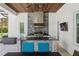 Outdoor kitchen features a grill, granite countertop, ceiling fan, and wood ceiling at 16121 Carencia Ln, Odessa, FL 33556