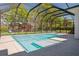 Sparkling swimming pool and splashpad surrounded by a screened enclosure and lush landscaping at 16121 Carencia Ln, Odessa, FL 33556