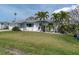 Inviting single-story home featuring a green lawn and attractive tropical landscaping at 16315 2Nd E St, Redington Beach, FL 33708