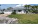 Charming single-story home with a well-manicured lawn and lush tropical landscaping at 16315 2Nd E St, Redington Beach, FL 33708