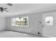 Bright living room boasts a ceiling fan and large window with a front yard view at 16315 2Nd E St, Redington Beach, FL 33708