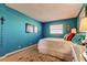 Turquoise-themed bedroom featuring artwork, a white bed, and laminate flooring at 1847 Shore Drive South # 308, South Pasadena, FL 33707