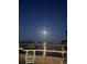 Relaxing nighttime waterfront view from a wooden deck featuring a lighted railing and serene atmosphere at 1847 Shore Drive South # 308, South Pasadena, FL 33707