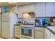 Functional kitchen design with white appliances and plenty of cabinet space at 1847 Shore Drive South # 308, South Pasadena, FL 33707