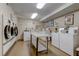 This community laundry room offers multiple washers and dryers, plus a folding table for residents' convenience at 1847 Shore Drive South # 308, South Pasadena, FL 33707