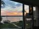 Sunset water view featuring a pier, lush greenery, and picturesque sky at 1847 Shore Drive South # 308, South Pasadena, FL 33707