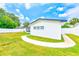 The backyard offers a pristine lawn, modern white siding, and a clean, white fence for added privacy at 1851 Glenville Dr, Clearwater, FL 33765