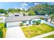 Desirable home boasting bright blue shutters, a well-kept lawn, and a modern driveway for ample parking at 1851 Glenville Dr, Clearwater, FL 33765