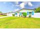 Well-maintained single-story home featuring a green lawn, manicured landscaping, and blue shutters at 1851 Glenville Dr, Clearwater, FL 33765