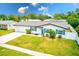Charming home featuring bright blue shutters, a well-manicured lawn, and a freshly painted driveway at 1851 Glenville Dr, Clearwater, FL 33765