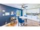 Eat-in kitchen area with blue accent wall, white cabinets, and decorative tile backsplash at 1851 Glenville Dr, Clearwater, FL 33765