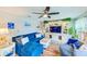 Comfortable living room featuring plush seating, a ceiling fan, and an entertainment center at 1851 Glenville Dr, Clearwater, FL 33765