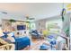 Cozy living room with comfortable blue seating, built-in shelving, and natural light from the window at 1851 Glenville Dr, Clearwater, FL 33765