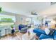 Comfortable living room featuring wood floors, plush seating, ceiling fan, and natural light at 1851 Glenville Dr, Clearwater, FL 33765