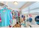 Organized walk-in closet with wood floor, shelving, hanging racks, storage cabinet, and window at 1851 Glenville Dr, Clearwater, FL 33765
