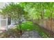 Private backyard featuring green grass, mature trees, and a wood fence at 220 Sawtooth Dr, Valrico, FL 33594