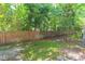 Backyard features a wood fence, verdant grass, and mature trees at 220 Sawtooth Dr, Valrico, FL 33594