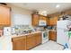 Bright kitchen with wooden cabinets, efficient appliances, and a clean, tiled floor for easy maintenance at 220 Sawtooth Dr, Valrico, FL 33594