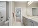 Well-lit bathroom features double sinks with granite countertops, white tile flooring, and tub/shower at 2904 W Averill Ave, Tampa, FL 33611