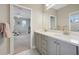 Bathroom boasts double sinks with gray cabinetry, granite countertops, and neutral decor at 2904 W Averill Ave, Tampa, FL 33611