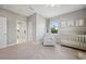 Comfortable bedroom with neutral decor, plush chair, crib, and open door to the bathroom at 2904 W Averill Ave, Tampa, FL 33611