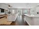Bright and airy living space with wood floors, white sectional sofa, and seamless flow to the kitchen area at 2904 W Averill Ave, Tampa, FL 33611
