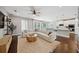 Bright, open-concept living area with hardwood floors, a modern white sofa, kitchen bar and stylish decor at 2904 W Averill Ave, Tampa, FL 33611